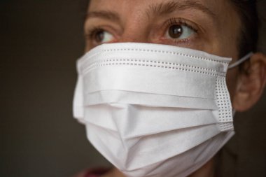  Bir kadın ağzına ve burnuna kağıt bir maske takar.