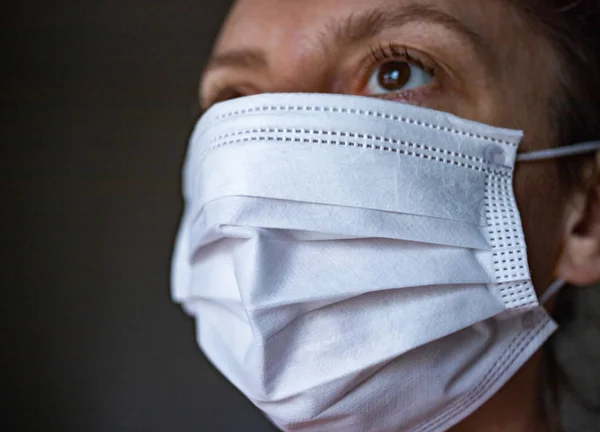 Une femme porte un masque facial en papier sur la bouche et le nez pour prot — Photo