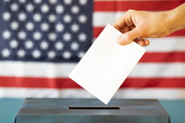 usa elections  the hand of woman putting her vote in the ballot box