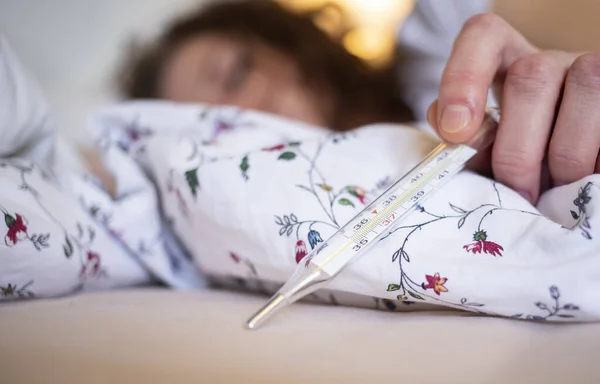 熱のあるベッドで女性は 温度計のコロナウイルスやCovid 19症状に焦点を当てます — ストック写真