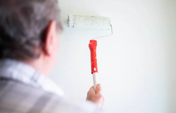 男性手绘墙壁与油漆辊 粉刷公寓 用白色油漆翻新 — 图库照片