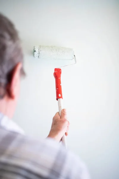 男性手绘墙壁与油漆辊 粉刷公寓 用白色油漆翻新 — 图库照片