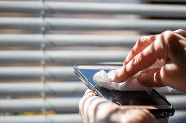 woman hands cleaning smartphone  sanitizing  coronavirus prevention