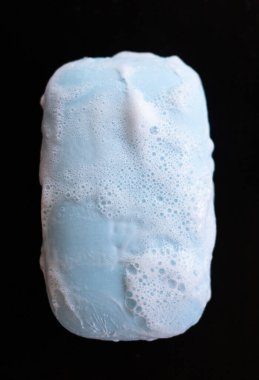 Siyah arka planda köpük köpüklü sabun kalıbı. Üst görünüm.