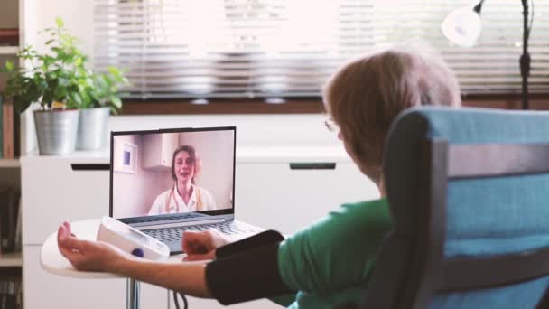 远程医疗概念 老年妇女在客厅里与医生进行在线咨询时使用平板电脑 自我隔离 — 图库视频影像