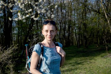 Bir kadın bahar ormanında tek başına yürüyor. 