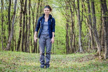 Yeşil ormanda tek başına yürüyen bir kadın.