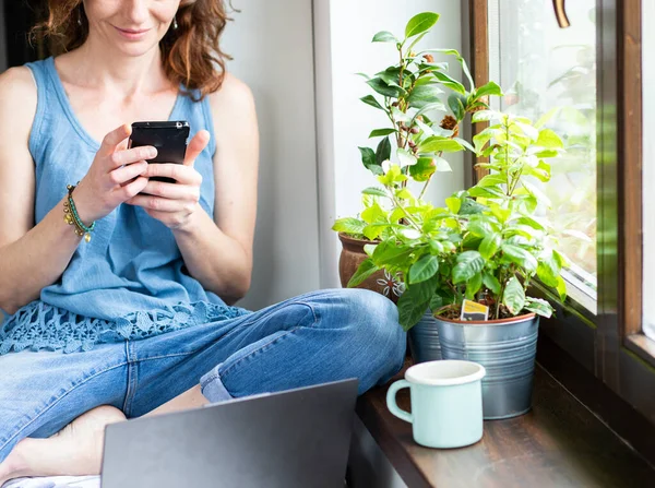Mulher Feliz Usando Smartphone Casa Pela Janela Conexão Mídia Social — Fotografia de Stock