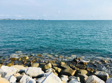 Resif sahili önü ve mavi gökyüzü olan boş deniz sahili manzarası