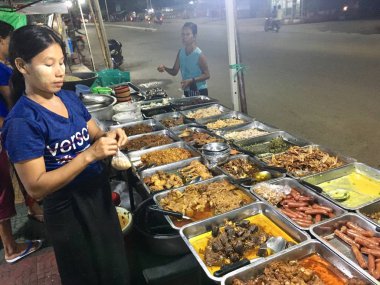 Birmanya usulü pirinçle yenen birçok çeşit yemek. Mandalay, Myanmar 'da yerel sokak yemeklerinin tadını çıkar.