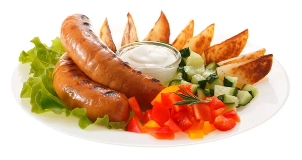 Sausages grilled with vegetables and sauce on the plate. Isolate — Stock Photo, Image