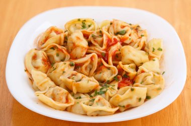 domates soslu bir tabakta ev yapımı haşlanmış mantı