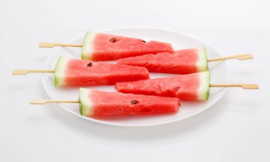 Karpuz beyaz plaka üzerinde sopa ile dilim. IC gibi görünüyor