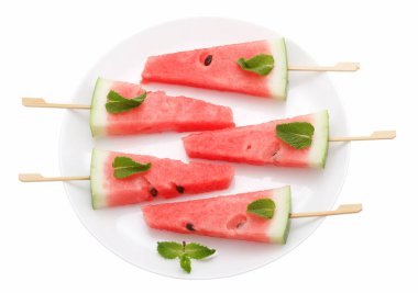Beyaz tabakta üzerine beyaz izole sopayla karpuz dilimleri
