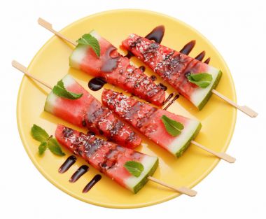 Whit üzerinde izole sarı plaka üzerinde sopa ile karpuz dilimleri