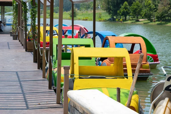 Colorful water bikes parked in order on river