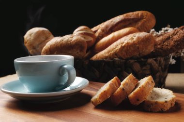 Taze ekmek ve bir bardak kahve ahşap siyah arka plan üzerinde