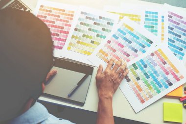 Grafiksel tasarım, renk örnekleri ve kalemler bir masanın üzerinde. Çalışma araçları ve aksesuarları olan mimari çizimler.