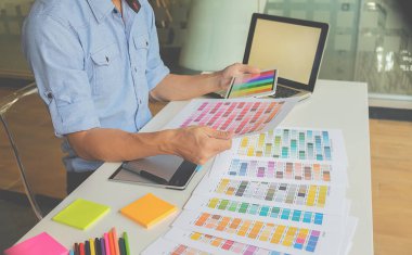 Grafiksel tasarım, renk örnekleri ve kalemler bir masanın üzerinde. Çalışma araçları ve aksesuarları olan mimari çizimler.