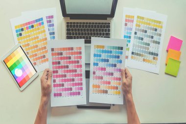 Grafiksel tasarım, renk örnekleri ve kalemler bir masanın üzerinde. Çalışma araçları ve aksesuarları olan mimari çizimler.