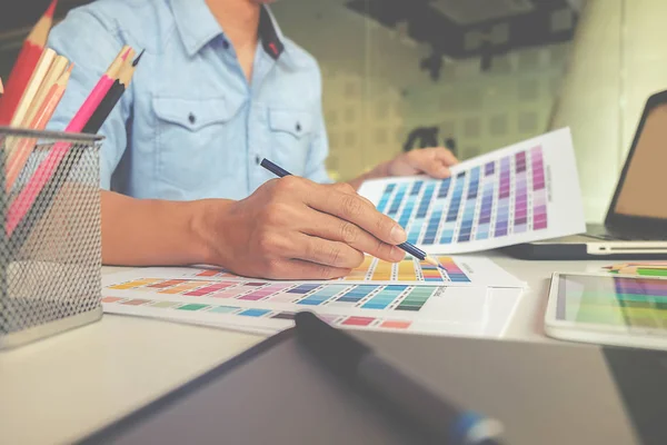 Graphic design and color swatches and pens on a desk. Architectural drawing with work tools and accessories.