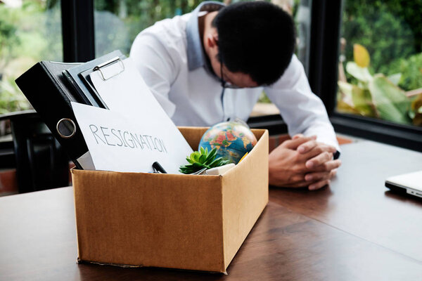  Sad dismissed businessman sitting outside the office after losi