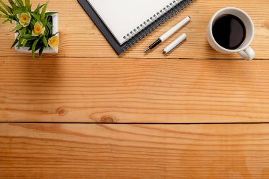 Ofis resepsiyon masası klavye, defter, kalem, bardak kahve ve çiçek ile. Kopya alanı ile Üstten Görünüm
