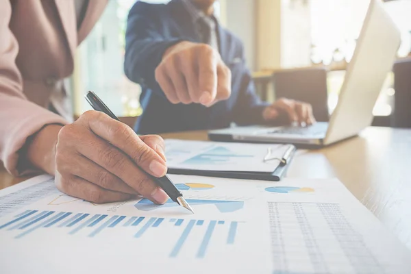 Affärsidé. Affärsmän diskuterar diagram och diagram som visar resultaten av deras framgångsrika lagarbete. — Stockfoto