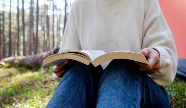 Kadın sabah sabah güneş ışığı ile çadır dışında bir kitap okuma. Ormanda kamp. Concep sakin ol