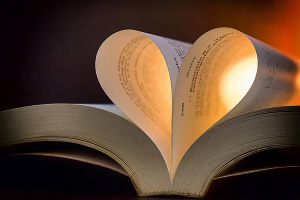 Boka med sidor i hjärta form över lysande bakgrund, Valentin — Stockfoto
