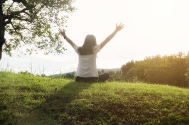 Bir fincan kahve ile yatağın üstüne oturan ve bir kitap okuma güzel Asyalı kadın. Bir kitap ve kahve ile sabah. Rahatlatıcı kavramı. Retro filtre efekti, yumuşak odak, seçici odak
