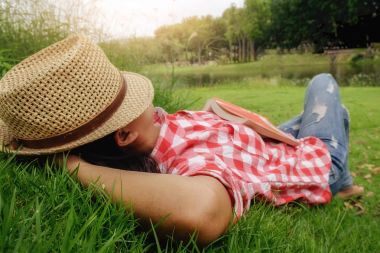 Açık havada mutlu görünüyordu ve bir kitap okuma rahatlatıcı bir kadın. Sabah bir kitapla. Rahatlatıcı kavramı. Retro filtre efekti, yumuşak odak, seçici odak