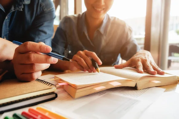 Concept d'éducation. Les étudiants étudient et réfléchissent au concept du campus. Gros plan des élèves discutant de leur sujet sur les livres manuels et écrivant sur un cahier. Concentration sélective . — Photo