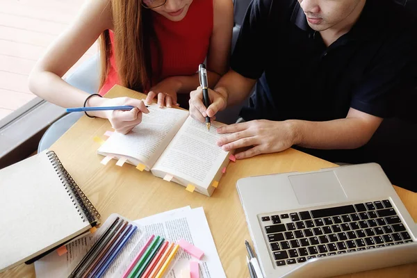 Concept d'éducation. Les étudiants étudient et réfléchissent au concept du campus. Gros plan des élèves discutant de leur sujet sur les livres manuels et écrivant sur un cahier. Concentration sélective . — Photo