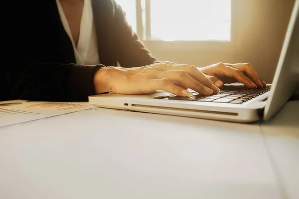 Mujer de negocios asiática gerente de análisis de datos en gráficos y mecanografía en la computadora, haciendo notas en documentos sobre la mesa en la oficina, color vintage, enfoque selectivo. Concepto empresarial . — Foto de Stock