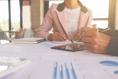 İş konsepti. İş adamları başarılı takım çalışmalarının sonuçlarını gösteren çizelge ve grafikleri tartışıyor.