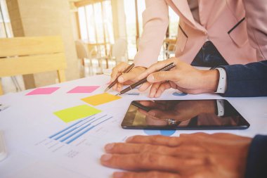 İş konsepti. İş adamları başarılı takım çalışmalarının sonuçlarını gösteren çizelge ve grafikleri tartışıyor.