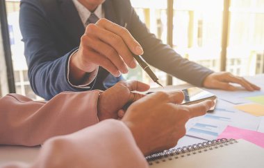 İş konsepti. İş adamları başarılı takım çalışmalarının sonuçlarını gösteren çizelge ve grafikleri tartışıyor.