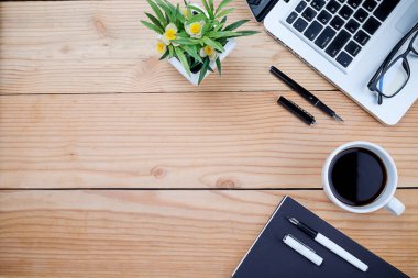 Ofis resepsiyon masası klavye, defter, kalem, bardak kahve ve çiçek ile. Kopya alanı (seçici odak ile Üstten Görünüm)