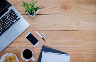 Ofis resepsiyon masası klavye, defter, kalem, bardak kahve ve çiçek ile. Kopya alanı (seçici odak ile Üstten Görünüm)