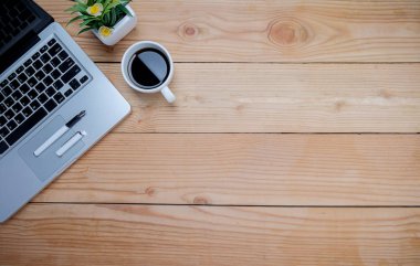 Ofis resepsiyon masası klavye, defter, kalem, bardak kahve ve çiçek ile. Kopya alanı (seçici odak ile Üstten Görünüm)