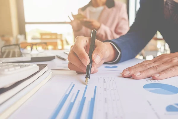 Conceito de negócio. Empresários discutindo os gráficos e gráficos que mostram os resultados de seu trabalho em equipe bem sucedido. — Fotografia de Stock