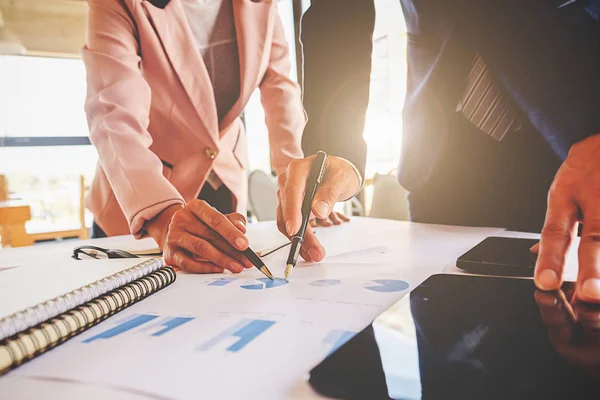 İş konsepti. İş adamları başarılı takım çalışmalarının sonuçlarını gösteren çizelge ve grafikleri tartışıyor.
