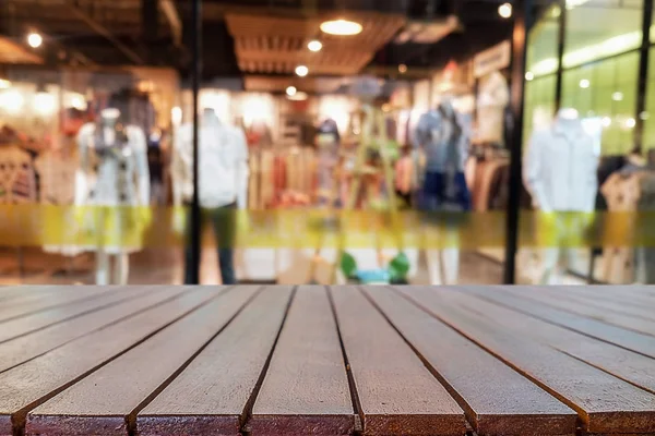 Empty wooden table space platform and blurred shopping mall or shopping center background for product display montage.