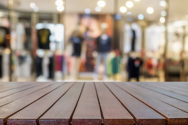 Empty wooden table space platform and blurred shopping mall or shopping center background for product display montage.