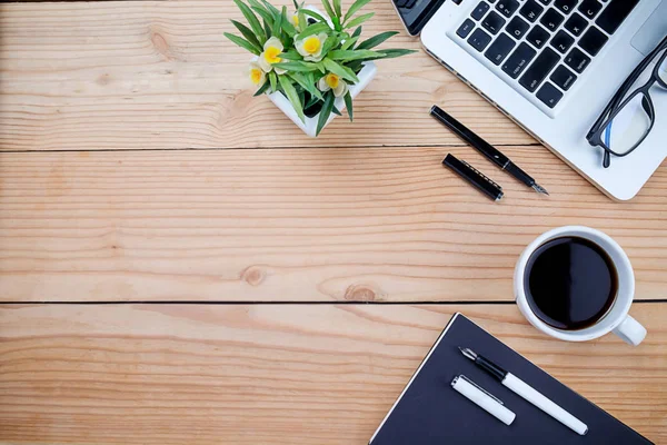 Ofis resepsiyon masası klavye, defter, kalem, bardak kahve ve çiçek ile. Kopya alanı (seçici odak ile Üstten Görünüm)