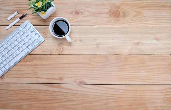 Ofis resepsiyon masası klavye, defter, kalem, bardak kahve ve çiçek ile. Kopya alanı (seçici odak ile Üstten Görünüm)