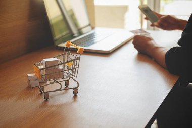 Internet online alışveriş konsept dizüstü bilgisayar ve alışveriş sepeti. Vintage sesi retro filtre efekti, yumuşak odak (seçici odak)