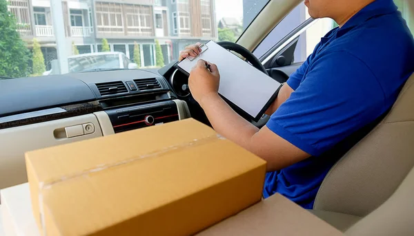 Delivery driver driving with parcels on seat.