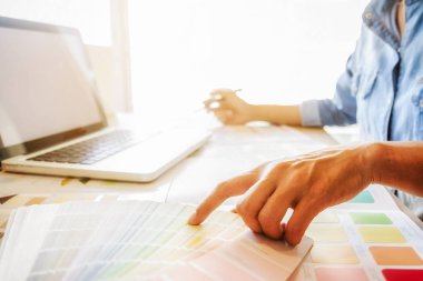 Grafiksel tasarım, renk örnekleri ve kalemler bir masanın üzerinde. Çalışma araçları ve aksesuarları olan mimari çizimler.